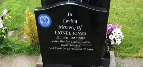 Polished black headstone in a churchyard